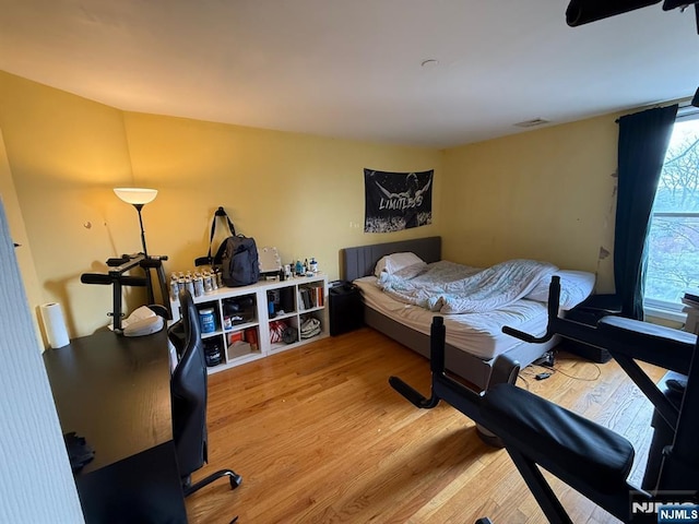 bedroom with wood finished floors and visible vents