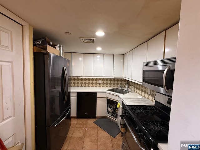 kitchen with visible vents, a sink, light countertops, white cabinets, and black appliances