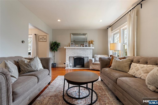 living room featuring recessed lighting, baseboards, wood finished floors, and a fireplace
