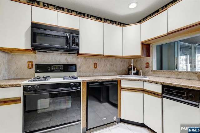 kitchen featuring light countertops, white cabinets, backsplash, and black appliances