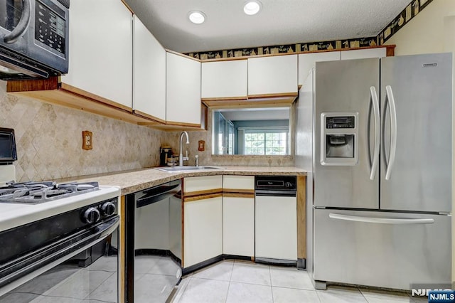 kitchen featuring light countertops, stainless steel fridge with ice dispenser, a sink, dishwashing machine, and gas range oven
