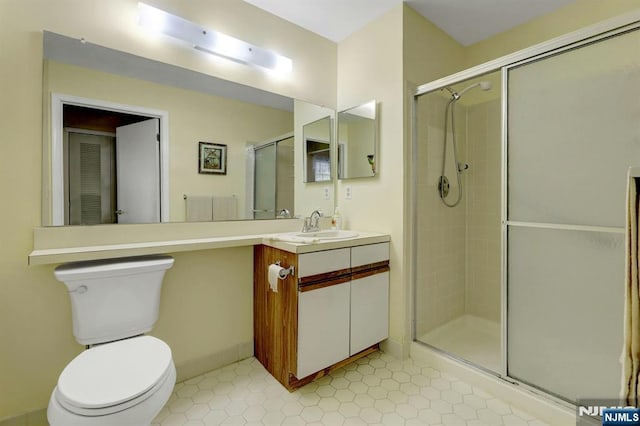 bathroom with vanity, tile patterned floors, a stall shower, and toilet