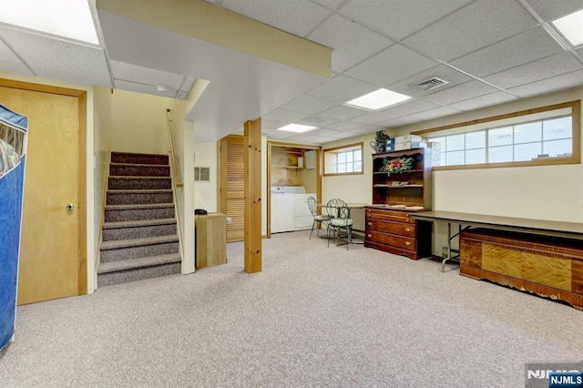 carpeted office space featuring washer and clothes dryer, a drop ceiling, and visible vents