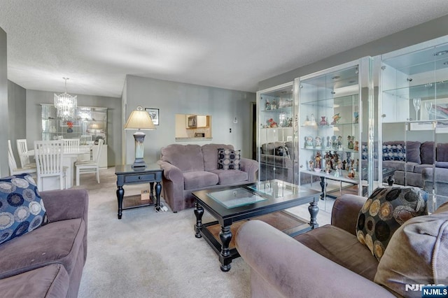 living area featuring carpet, a textured ceiling, and a notable chandelier