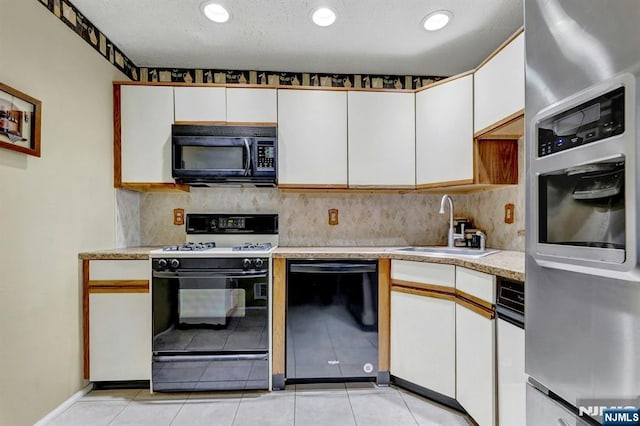 kitchen with light countertops, white cabinets, tasteful backsplash, a sink, and black appliances