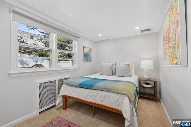 bedroom with baseboards, visible vents, radiator heating unit, and carpet