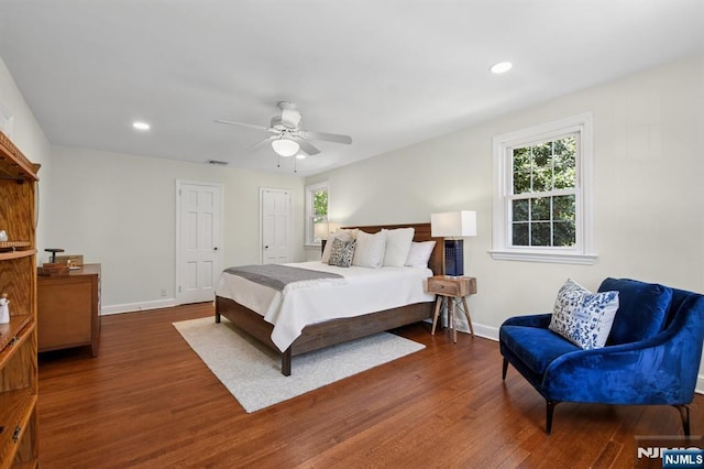 bedroom with baseboards, dark wood-style flooring, and visible vents