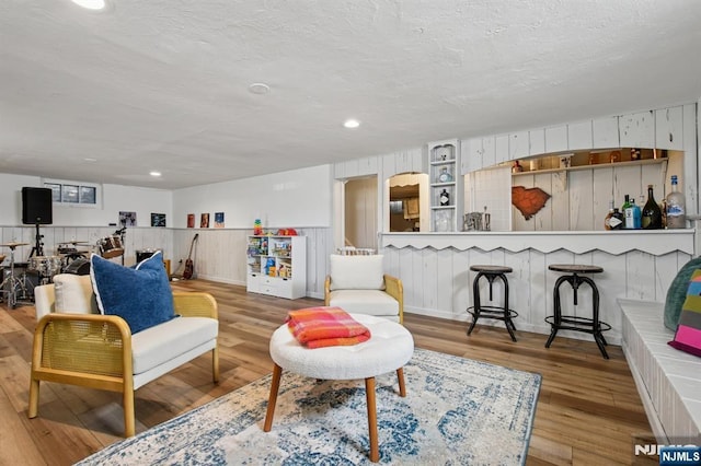 living area with recessed lighting, a textured ceiling, and wood finished floors