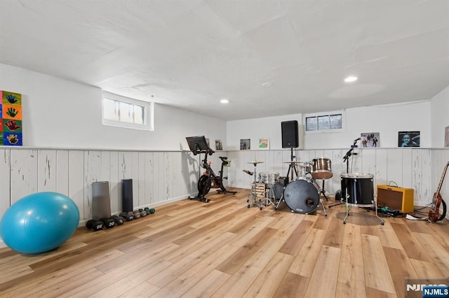 exercise area featuring recessed lighting, wainscoting, and hardwood / wood-style floors