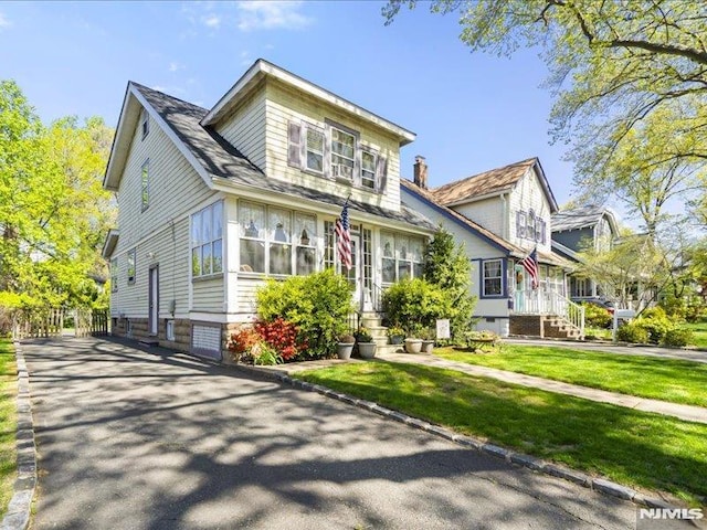 bungalow with a front yard and entry steps