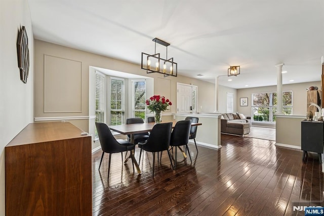 dining room with decorative columns, dark wood-style flooring, baseboards, an inviting chandelier, and recessed lighting