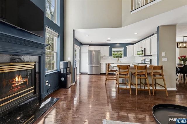 interior space with white cabinets, light countertops, stainless steel appliances, decorative backsplash, and dark wood-style floors