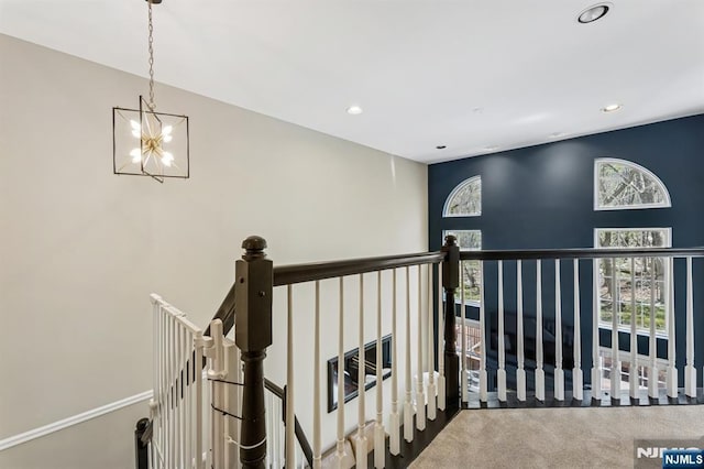 hall featuring an inviting chandelier, carpet floors, recessed lighting, and an upstairs landing