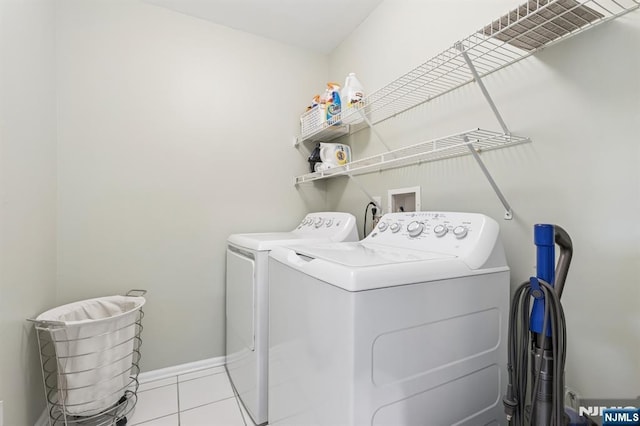 washroom with laundry area, baseboards, light tile patterned floors, and washer and dryer