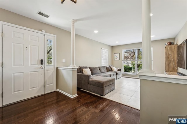 entrance foyer featuring baseboards, decorative columns, visible vents, and hardwood / wood-style floors