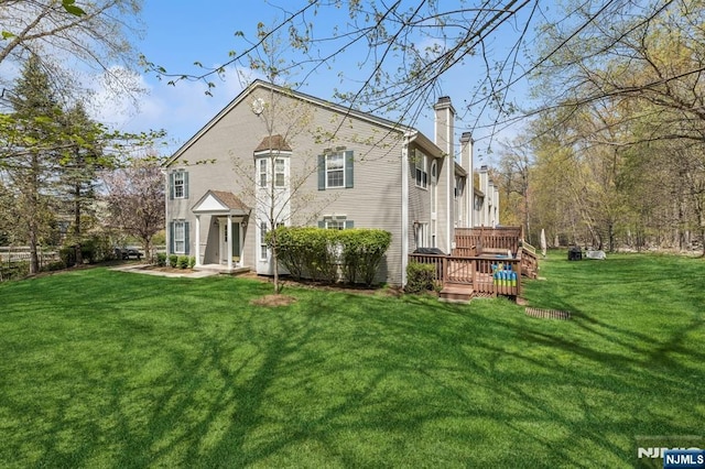 exterior space with a chimney, a front lawn, and a deck