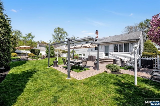 back of property with a lawn, a pergola, fence, and a patio area