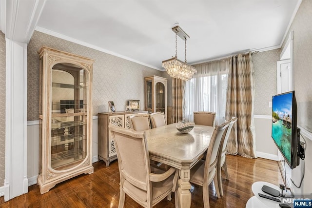 dining room with crown molding, wallpapered walls, wood finished floors, and a chandelier