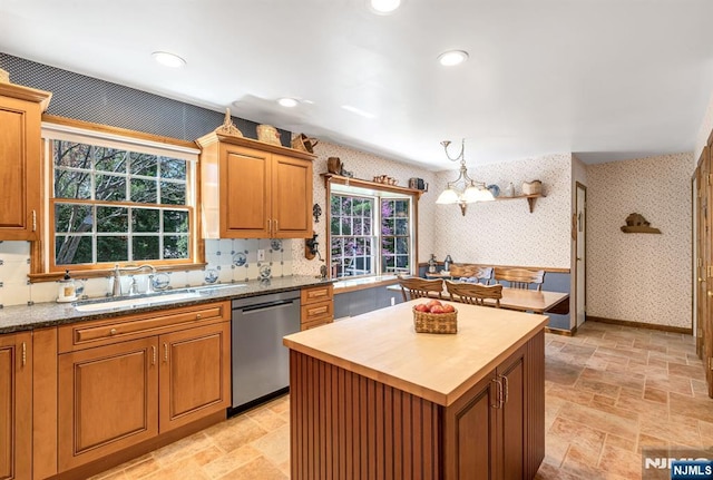 kitchen featuring dishwasher, a sink, butcher block counters, a notable chandelier, and wallpapered walls