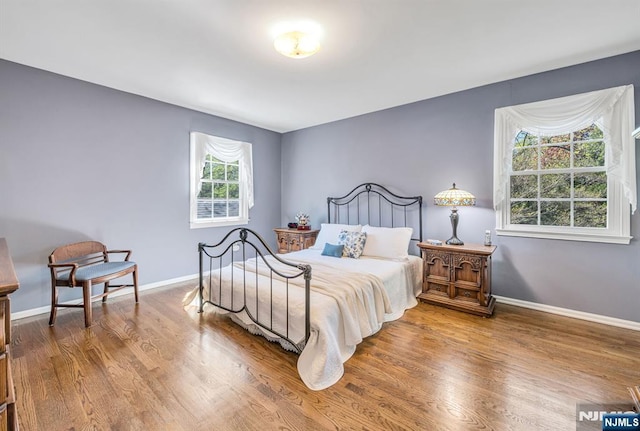 bedroom with baseboards and wood finished floors