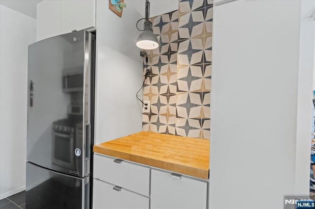 kitchen with white cabinetry, wooden counters, and stainless steel fridge with ice dispenser