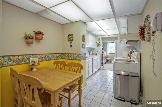 kitchen with range, a paneled ceiling, light tile patterned floors, light countertops, and white cabinets