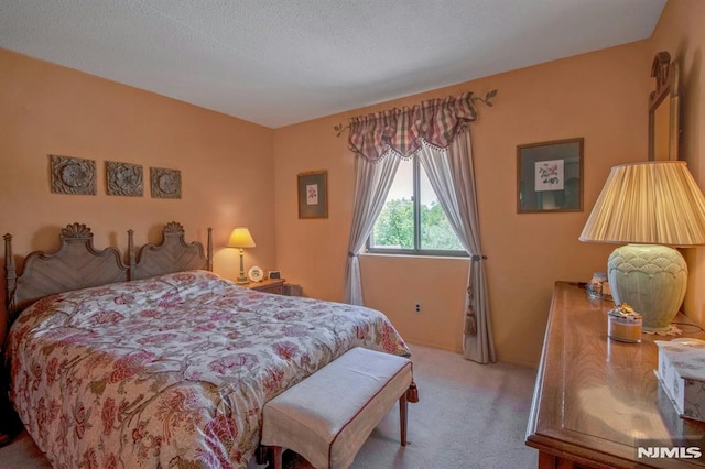 bedroom with carpet flooring and a textured ceiling