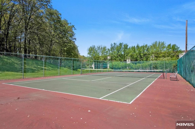 view of tennis court with fence and community basketball court