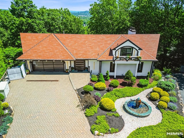 18 Fairview Dr, North Caldwell, NJ 07006 - view of front of home with an attached garage, stucco siding, driveway, and a chimney