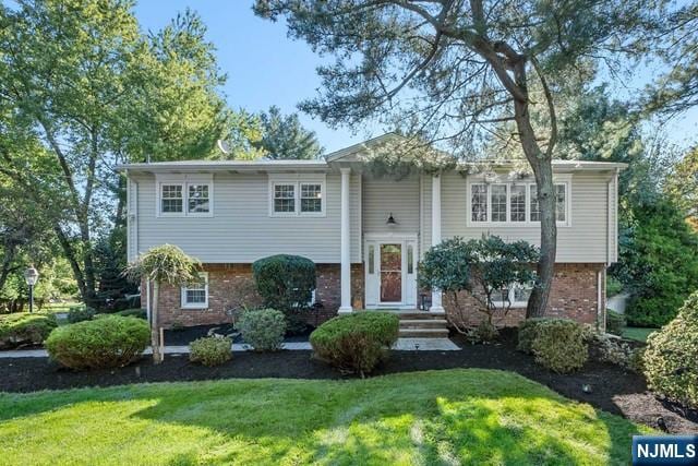 bi-level home featuring brick siding and a front yard