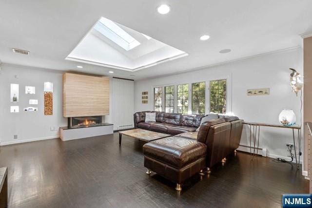 living room with wood finished floors, visible vents, baseboard heating, and a fireplace