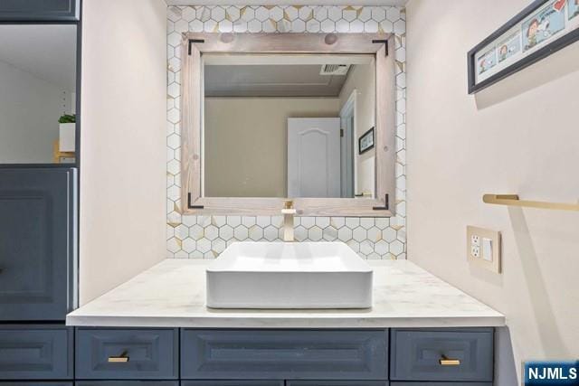 bathroom featuring vanity and decorative backsplash