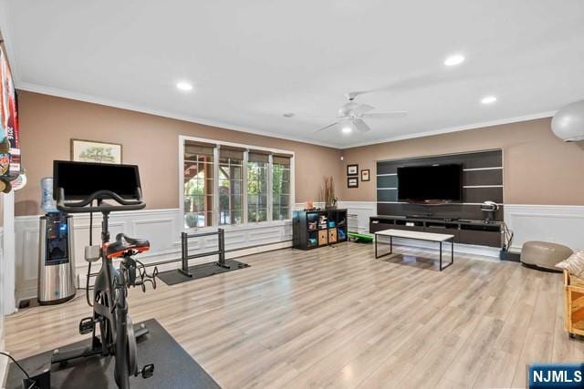 workout area with a decorative wall, ornamental molding, wainscoting, and ceiling fan