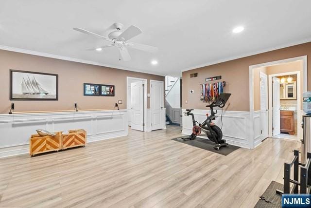 workout area featuring crown molding, light wood-type flooring, a ceiling fan, and recessed lighting