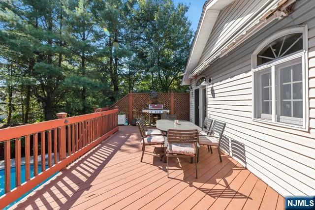 wooden deck with area for grilling and outdoor dining space
