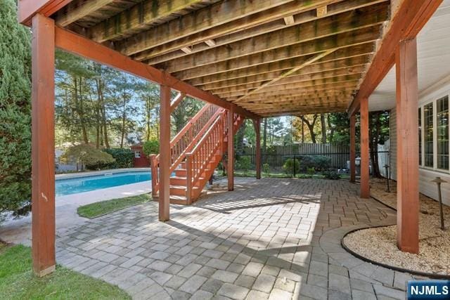 view of patio featuring fence, stairs, and a fenced in pool