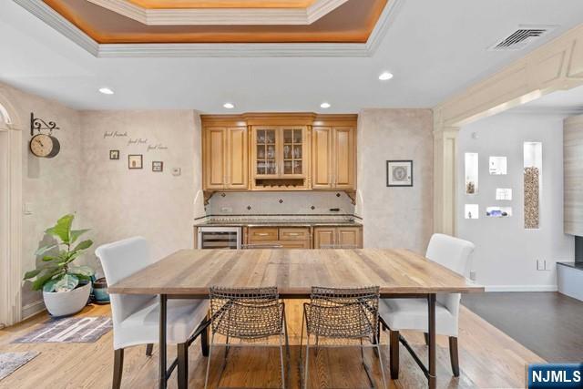 dining area with recessed lighting, ornamental molding, and light wood-style flooring