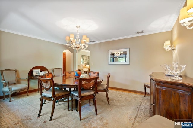 dining space with visible vents, baseboards, crown molding, and a chandelier
