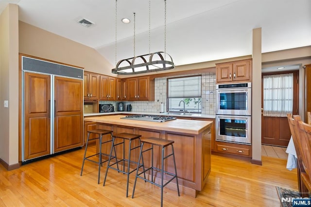 kitchen featuring visible vents, wooden counters, double oven, and paneled fridge