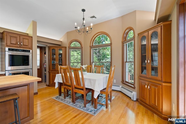 dining area featuring visible vents, a baseboard heating unit, light wood-style flooring, and a chandelier