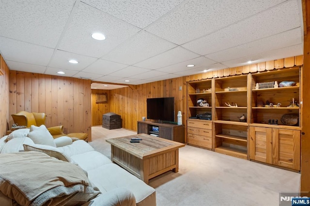living area with recessed lighting, wood walls, light carpet, and a drop ceiling