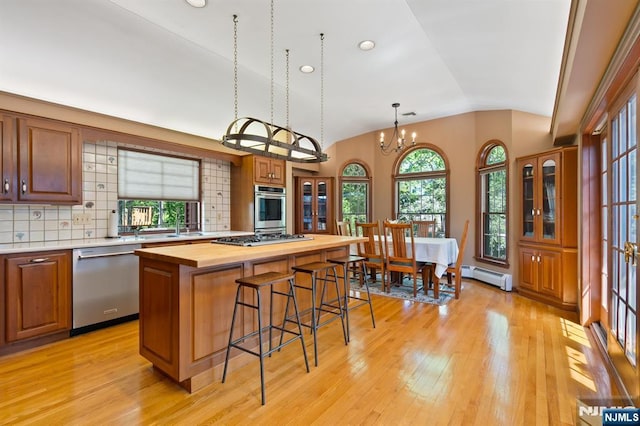kitchen featuring appliances with stainless steel finishes, wooden counters, light wood-style flooring, and lofted ceiling
