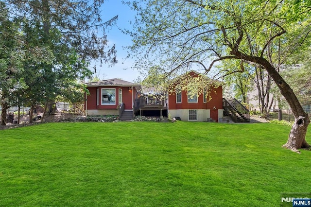 back of property with stairway, a lawn, and a wooden deck