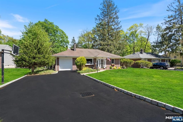 ranch-style house featuring brick siding, a front lawn, aphalt driveway, and a chimney