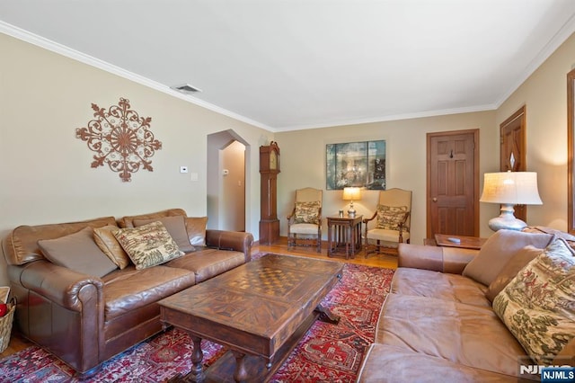 living area with visible vents, arched walkways, wood finished floors, and ornamental molding