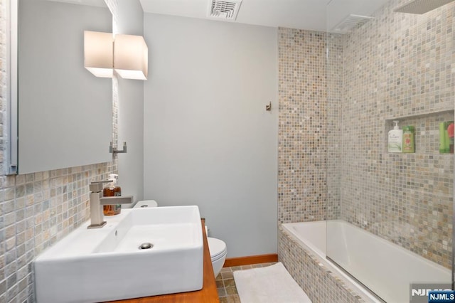 bathroom featuring a sink, tile patterned flooring, toilet, baseboards, and visible vents