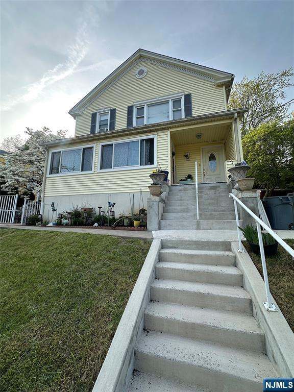 traditional home with covered porch and a front yard