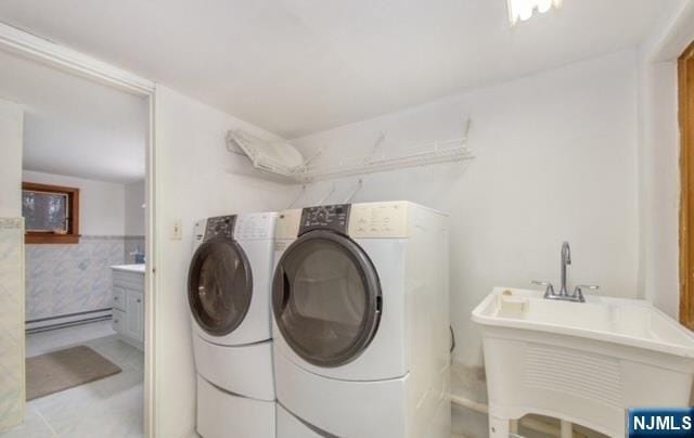laundry area with a sink, laundry area, a baseboard heating unit, and washer and clothes dryer
