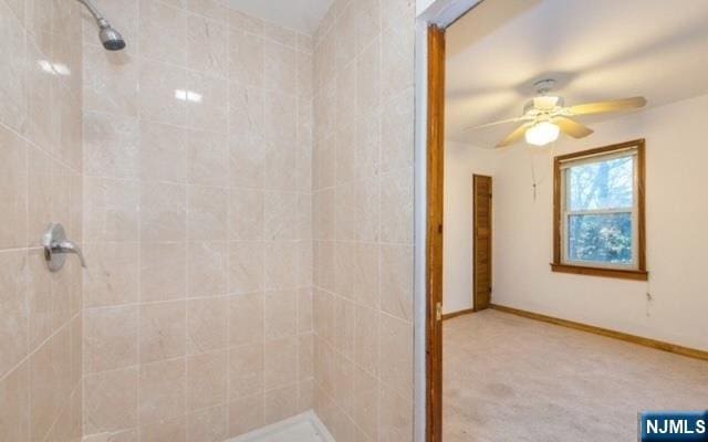 bathroom featuring baseboards, ceiling fan, and a tile shower