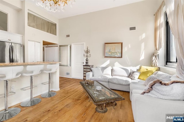 518-536 Gregory Ave Unit C408, Weehawken, NJ 07086 - living area featuring a high ceiling, a chandelier, light wood-style floors, and baseboards